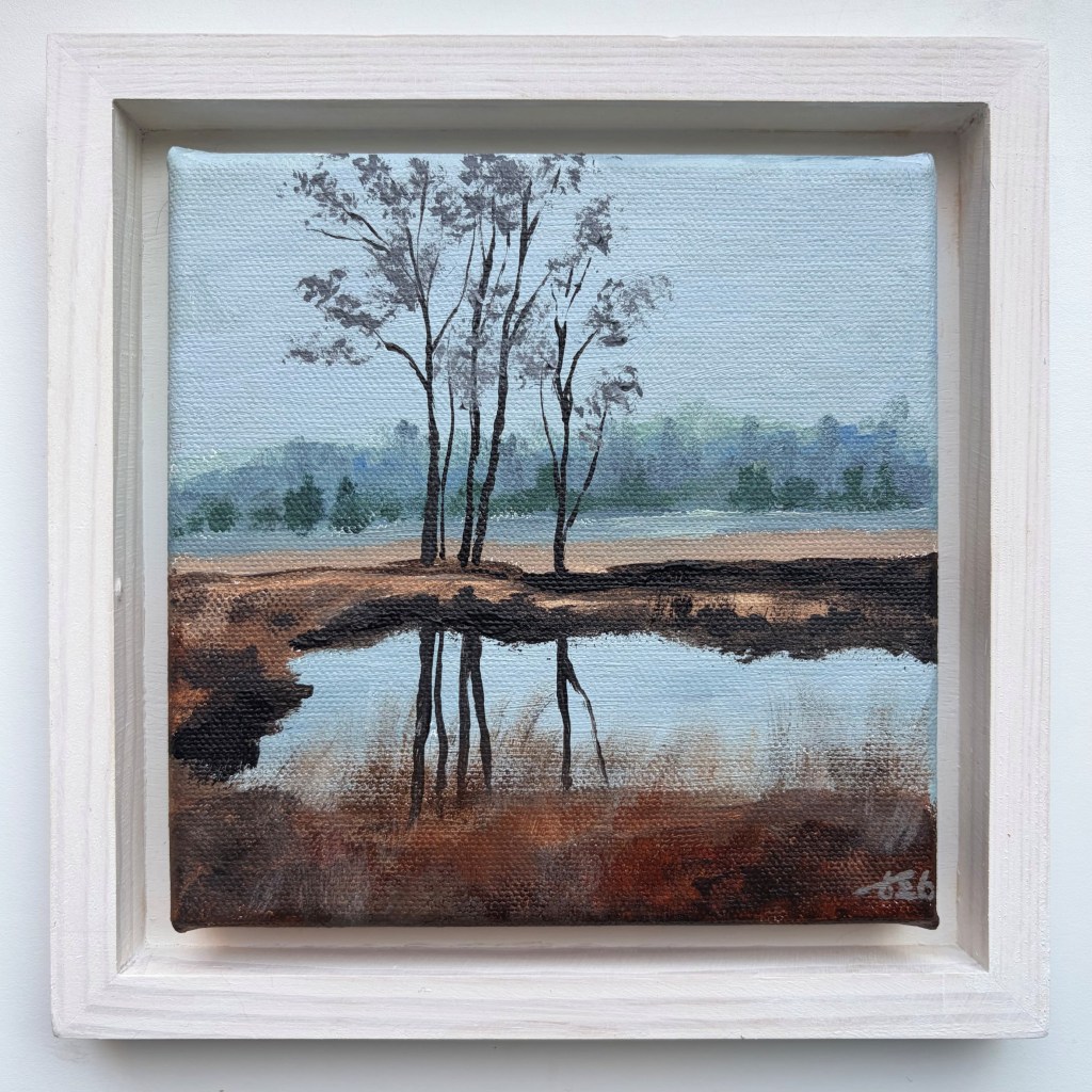 Miniature acrylic painting of slender trees reflected in a still heathland pool, surrounded by brown vegetation and a misty blue-grey landscape, in a white wooden floating frame.