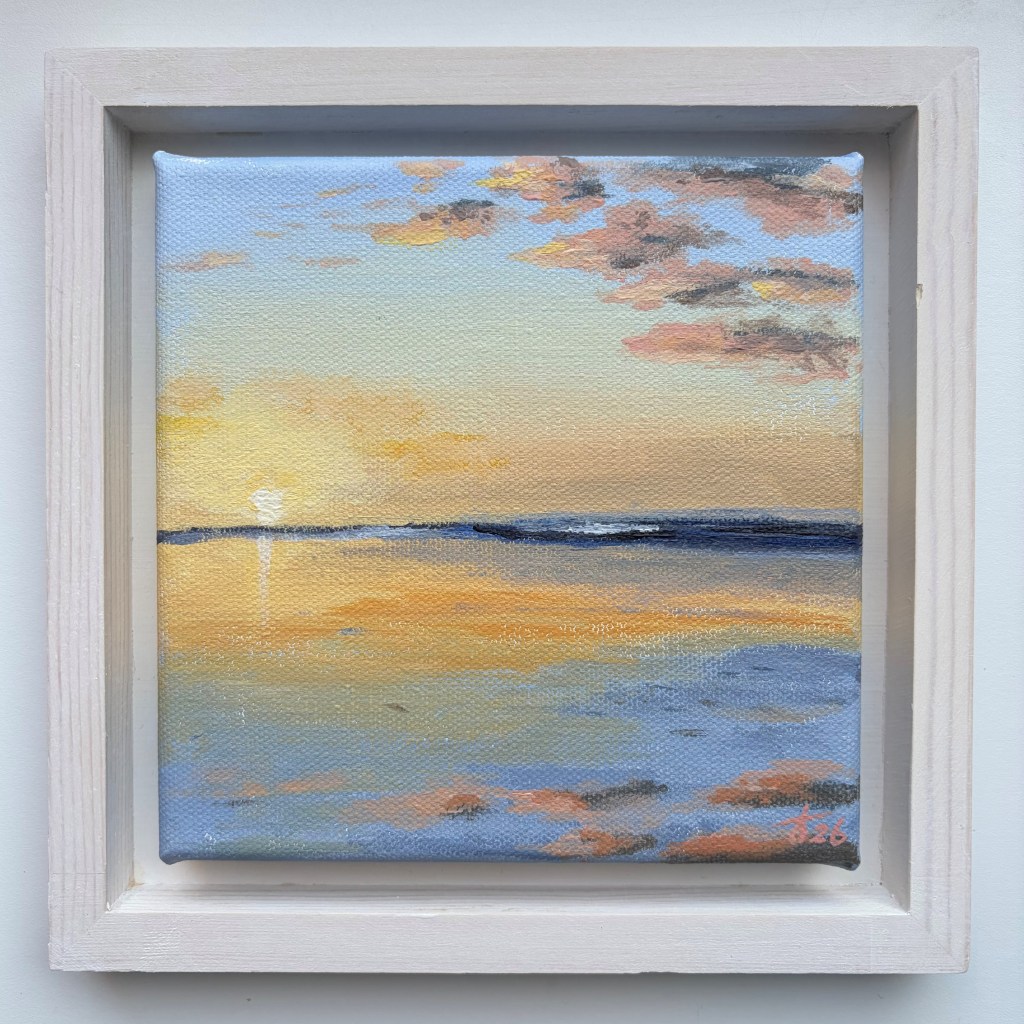 Miniature acrylic painting of a golden sunset over calm water, with blue, peach and grey clouds reflected in the surface, in a white wooden floating frame.